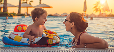 mother and toddler son in pool at resort