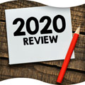Image of a piece of paper that reads '2020 Review' on a wood table with a pencil