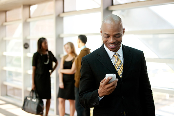 man smiling as he looks at his phone