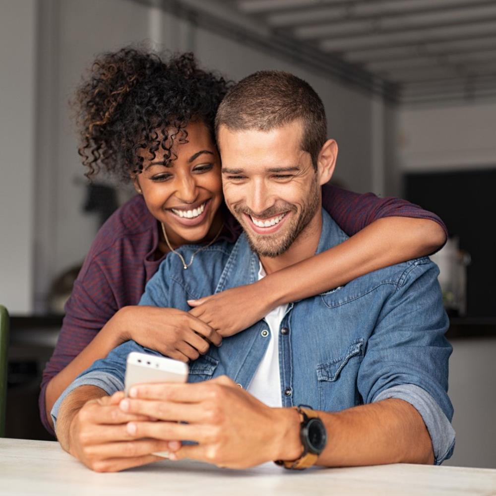 Couple happily looking at phone
