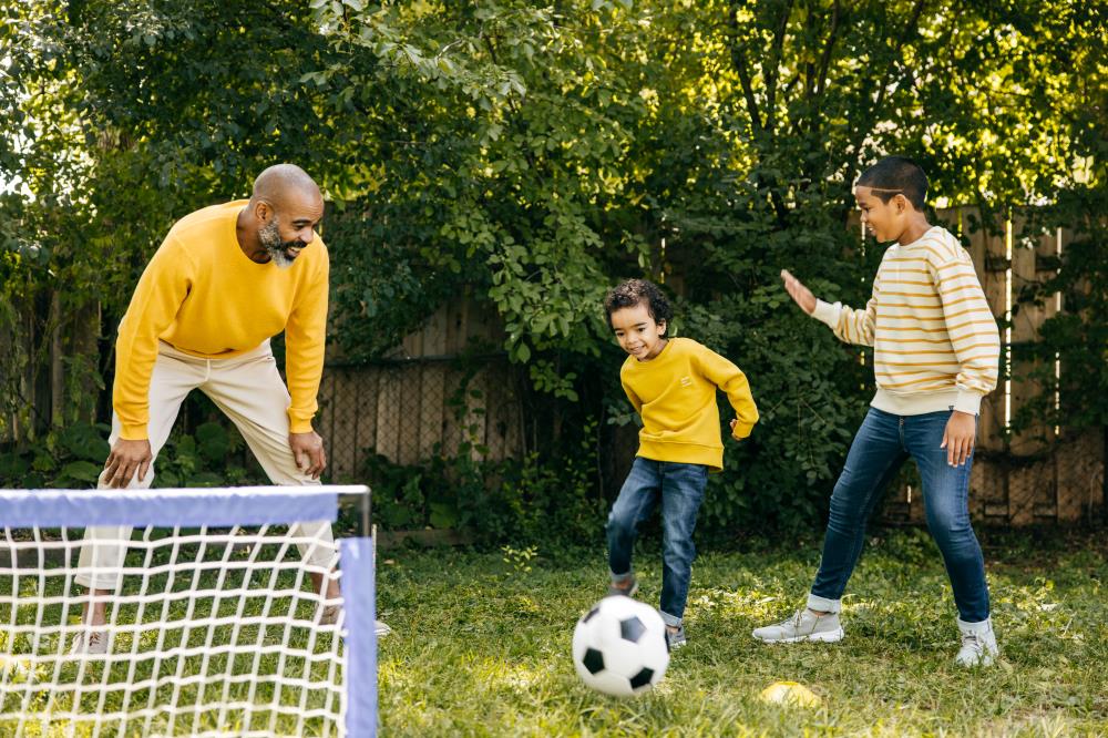 Family Playing Soccer in the Back Yard