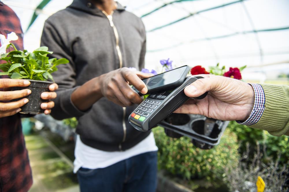 Man Using HOPE Reward Visa Credit Card to Pay for Plants at a Nursery Using a HOPE Digital Wallet