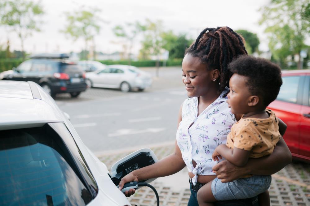 Woman with Son Charging an Electric Vehicle