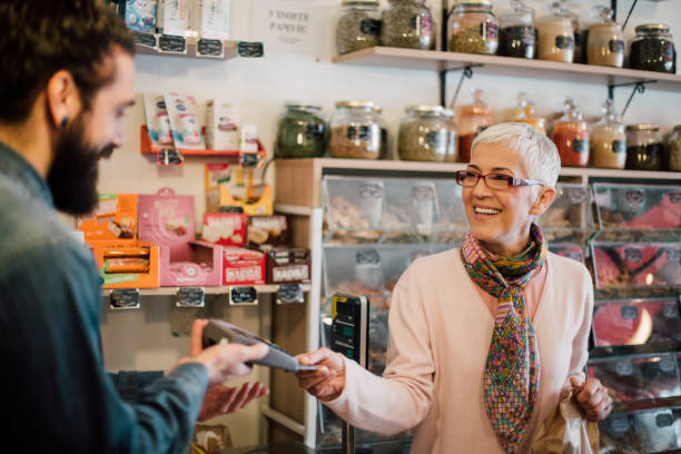 Older woman paying for purchase with HOPE Credit Card