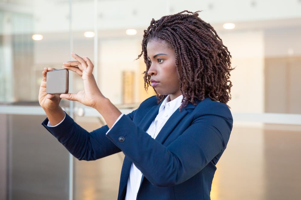Businesswoman using  smartphone for Member Verifying Identity with IDCheck for Shared Branching