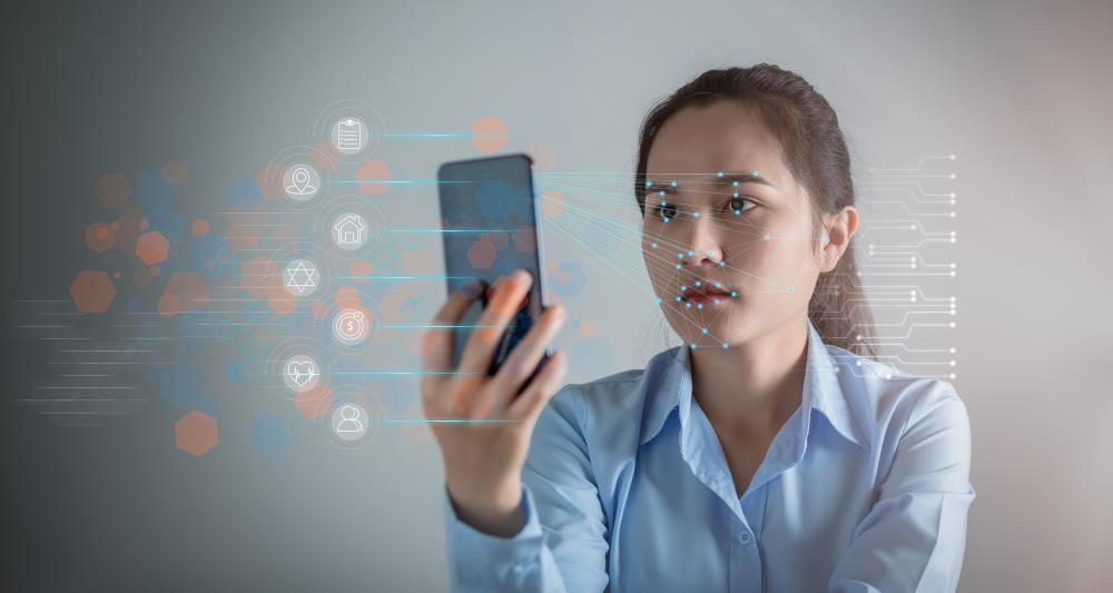 Asian woman scanning face with facial recognition system on smartphone for verify identitwith IDCheck for Shared Branching
