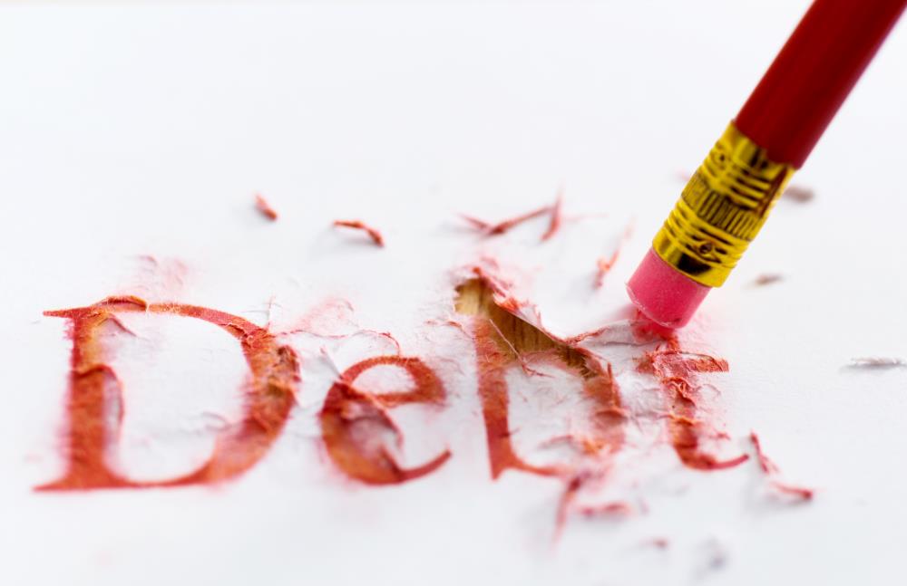 The Word Debt on a Piece of Paper Being Erased by a Pencil Eraser