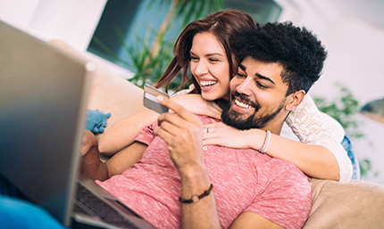A man and woman smiling with the man holding a credit card - image links to article: Why Visa Platinum is the Best Cash Back Credit Card
