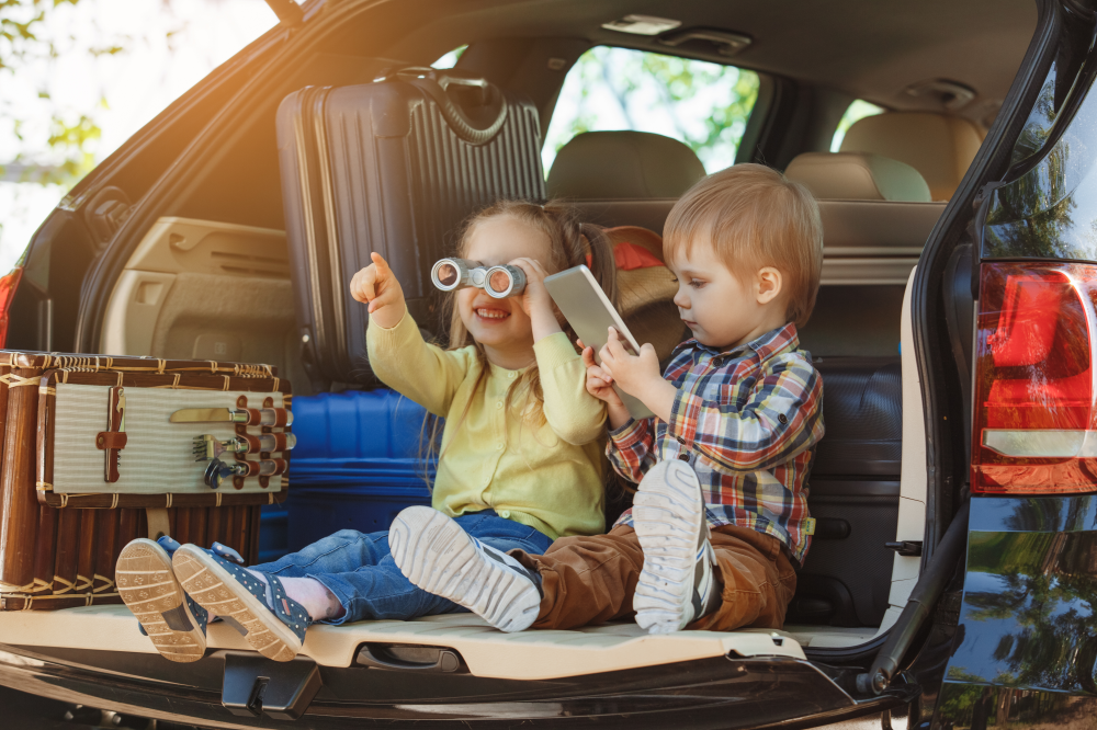 A girl and a boy sitting in the back of a car - links to Auto Refinance page