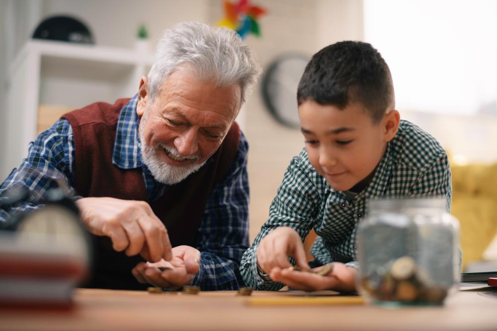 An older man and younger boy with coins on a table