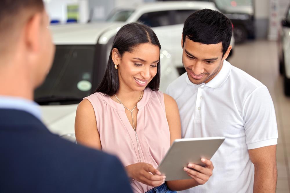 A couple looking at a tablet in a dealership